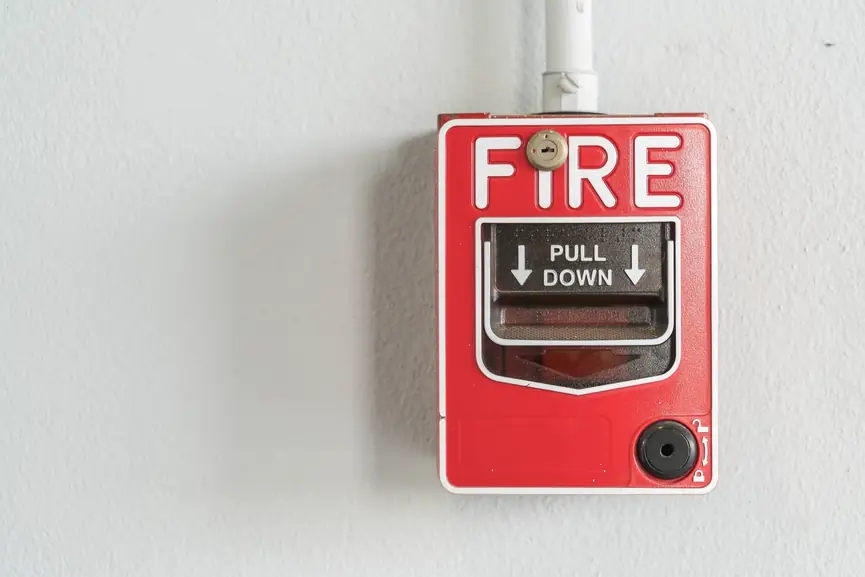 1888 Red fire alarm pull station mounted on a white wall, featuring instructions to "PULL DOWN," emphasizing fire safety and emergency response systems relevant to Reliable Fire Protection's services.