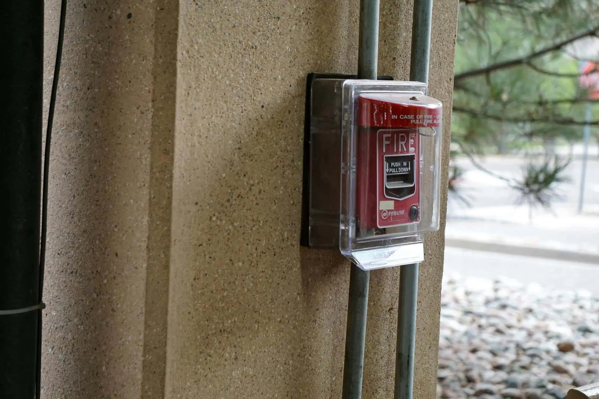 Fire alarm pull station under a clear protective cover on an outdoor column