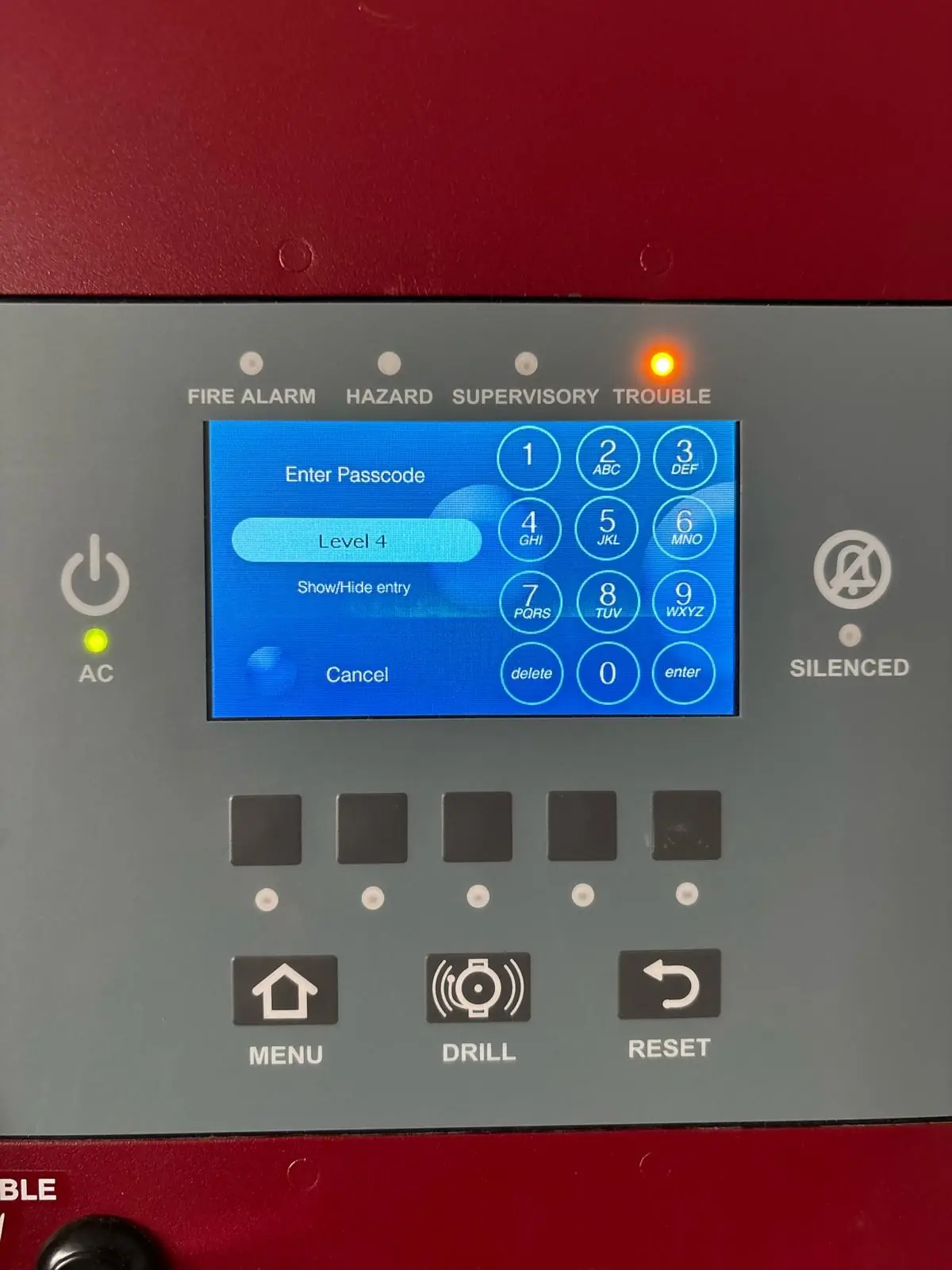 Touchscreen fire alarm panel with the trouble indicator lit