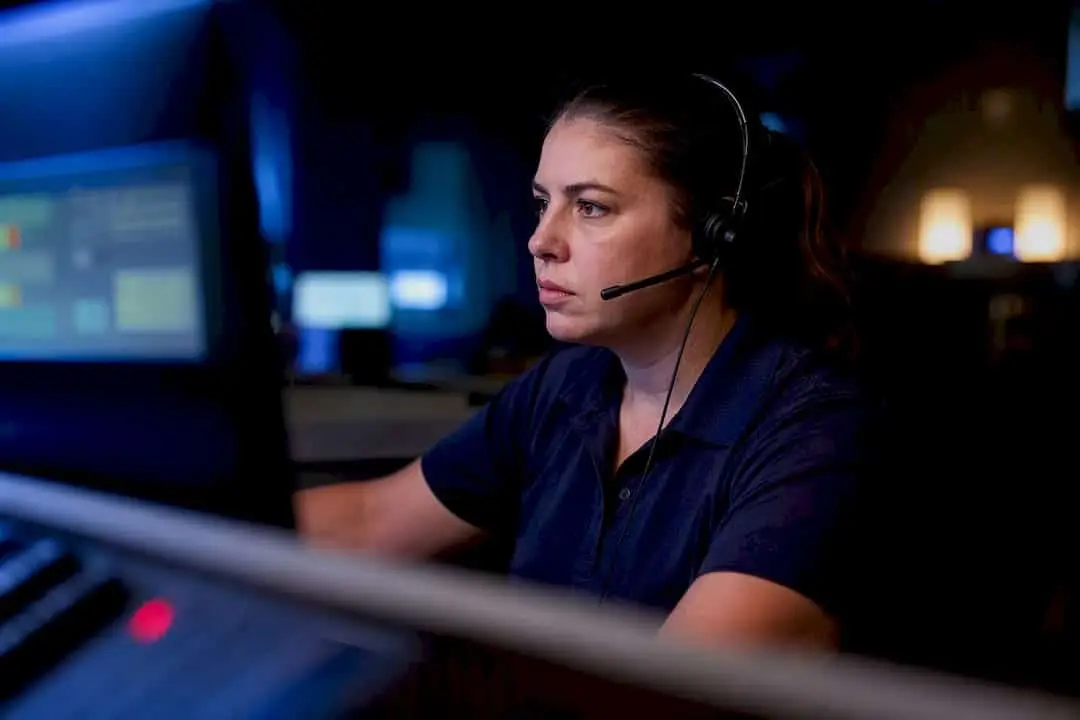 Operator with a headset watching fire alarm monitoring screens