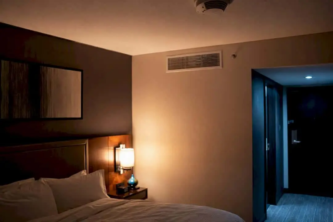 Hotel room with a ceiling smoke detector above the bed